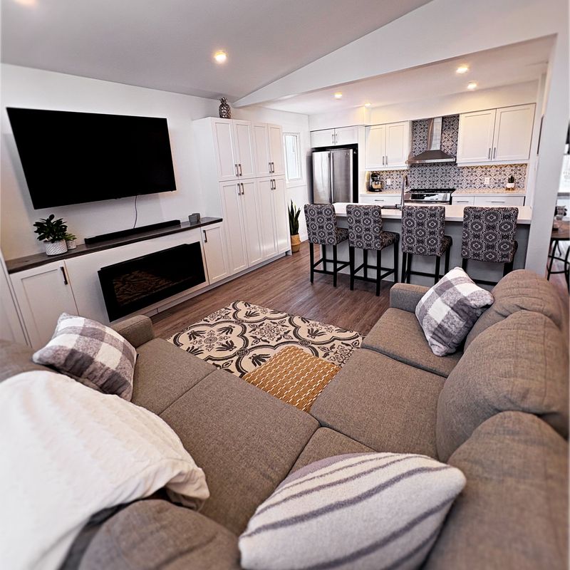 Open-concept lower level with a fireplace, kitchen and seating area