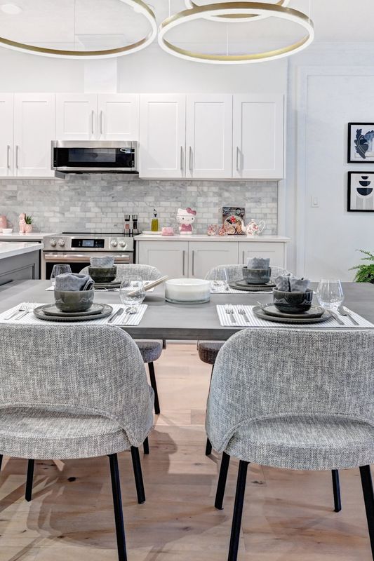 Bright white kitchen with brass ring pendants over the dining table