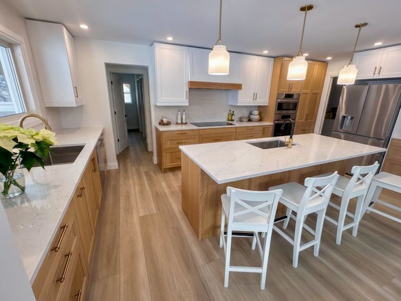 Warm wood and white kitchen with a quartz-topped island and pendant lighting