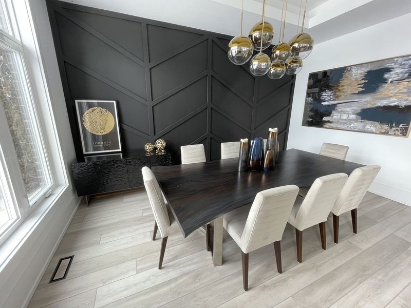 Dining room with a chevron-panelled accent wall and brass globe chandelier