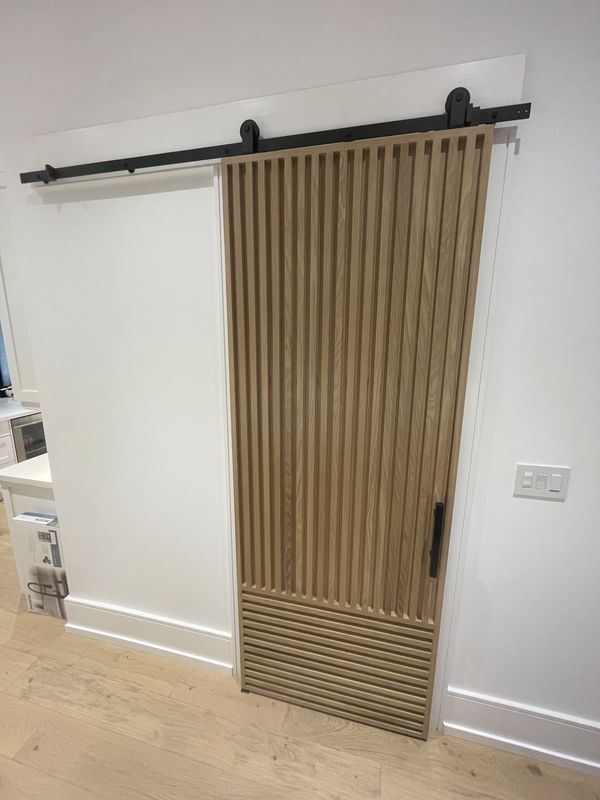 Custom white oak slat barn door on a black rail