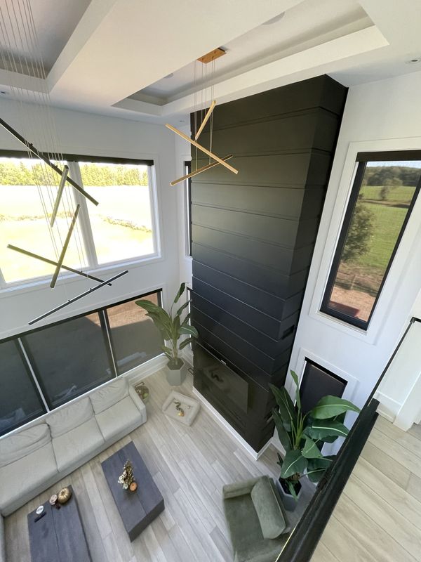 Two-storey living room with a black vertical-panel accent wall