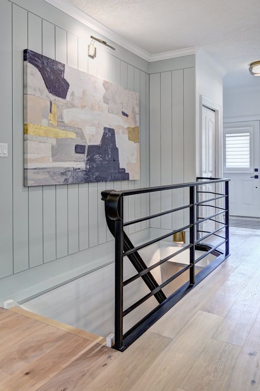 Horizontal black railing against a painted shiplap feature wall